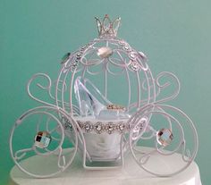 a white birdcage filled with shoes and jewelry on top of a cake stand