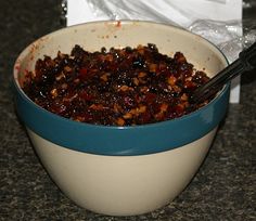 a blue and white bowl filled with food on top of a counter next to a bag