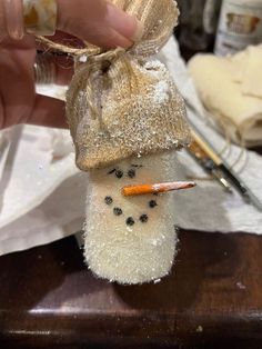 someone is making a snowman ornament out of cotton swaddled in burlap