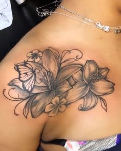 a close up of a woman's breast with flowers and butterflies on the side