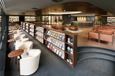 a library with chairs, tables and bookshelves filled with lots of books on shelves