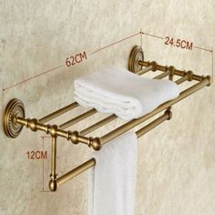 the brass towel rack has two white towels on it