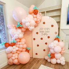 balloons are arranged in the shape of an arch with strawberrys and polka dots on it