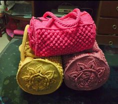 three knitted purses sitting on top of a glass table next to a dresser