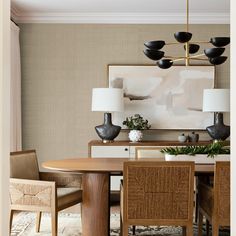 a dining room table with four chairs and a chandelier hanging from the ceiling