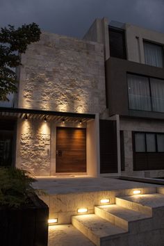 an image of a house at night with lights on the front and side doors open