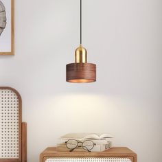 a pair of glasses sitting on top of a wooden table next to a lamp shade