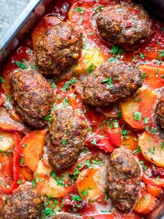 meatballs and vegetables are in a pan with tomato sauce on the side, ready to be eaten