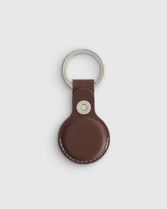 a brown leather keychain with a white stitching on the front and bottom