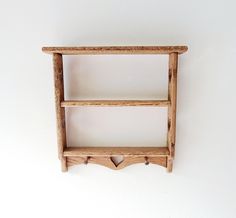 a wooden shelf with two hearts on the bottom and one heart at the top, against a white wall