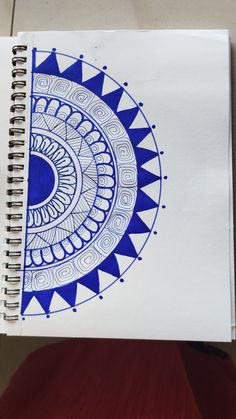 a spiral notebook with blue and white designs on it