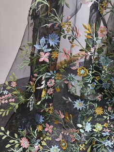 the sheer fabric is decorated with flowers and leaves