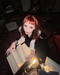 a woman sitting at a table with an open book