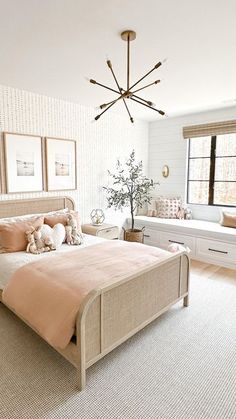 a bedroom with a bed, dressers and window in the corner is decorated in neutral colors