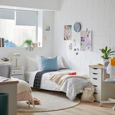 a bedroom with white brick walls and wooden flooring is furnished with various furniture, including a small bed