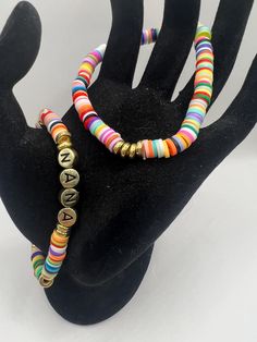 Set of 2 rainbow clay bead bracelets with gold accents and "Nana" in gold with black letters. Both 7" Clay Bead Bracelets, Clay Bead, Bead Bracelets, Black Letter, Gold Accent, Clay Beads, Gold Accents, Jewelry Bracelets, Beaded Bracelets