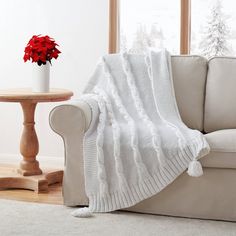 a living room with a white couch and red poinsettia