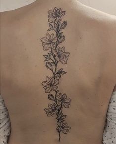 the back of a woman's neck with flowers on it