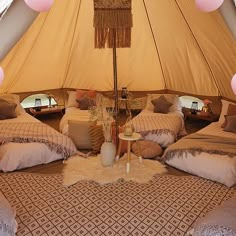 a large tent with several beds and pillows in it