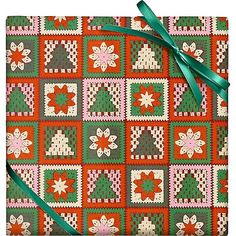 an orange and green quilted gift wrapper with a bow on it's side