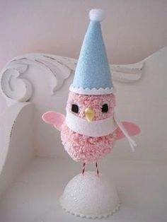 a pink bird with a blue and white hat