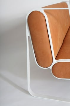 an orange leather chair sitting on top of a white table