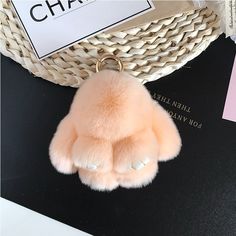 a pink pom - pom keychain sitting on top of a table