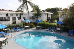 an empty swimming pool surrounded by lawn chairs and umbrellas