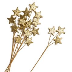 three gold stars on top of each other in the shape of hair pins with long stems