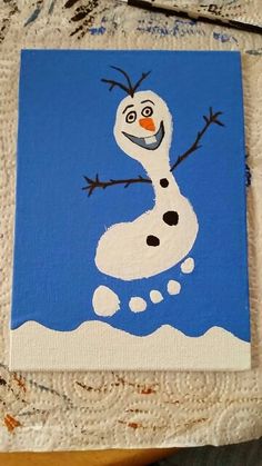 a painting of a snowman is shown on a piece of paper with blue background