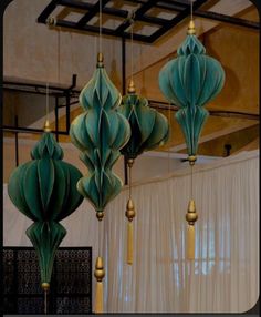 three green paper lanterns hanging from the ceiling