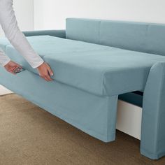 a person is pulling out the back end of a couch