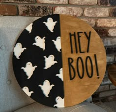 a wooden sign that says hey boo with ghost faces on it and the words hey boo written in black