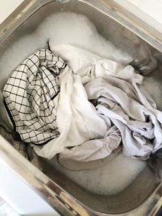 a metal container filled with clothes on top of a counter