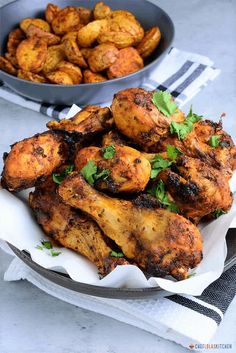 air fryer chicken legs with parsley on top and in a bowl next to it