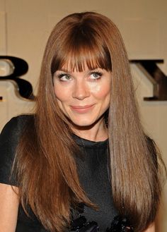 a woman with long brown hair and bangs