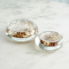 two glass dishes sitting on top of a marble counter