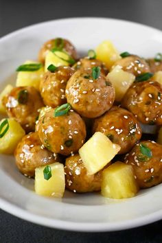 a white plate topped with meatballs and pineapples