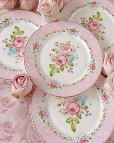 there are many pink roses on the plates