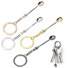 four keychains with different colors and shapes on them, one is gold, the other is silver