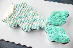 two cupcakes with blue frosting and white icing are on a tray