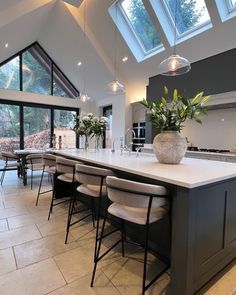 a large kitchen with an island in the middle and lots of seating around it for people to sit at