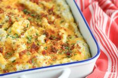 a casserole dish with cheese and bacon in it on a red and white towel