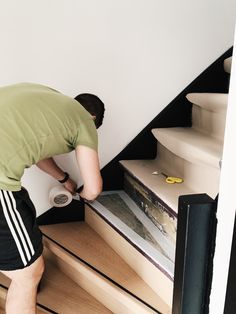 a man is painting the stairs in his home