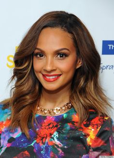 a close up of a person wearing a colorful dress and smiling at the camera with an orange lip