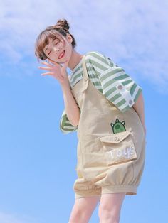 a woman is posing with her hand up to her face while wearing a green and white striped shirt