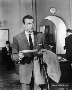 a man in a suit and tie holding a piece of paper