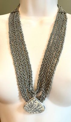 I made this Handmade braded seed bead and German Dendrite and silver Artsy / Boho necklace. It can be worn long or shorter. measures 24", but also has a generous extender. Gray Beaded Multi-strand Jewelry, Silver Long Beaded Necklace With Polished Beads, Silver Polished Beaded Long Necklace, Silver Polished Long Beaded Necklace, Silver Multi-strand Bohemian Beads, Silver Beaded Multi-strand Necklace, Silver Bohemian Multi-strand Beads, Silver Faceted Beads Lariat Necklace, Silver Multi-strand Beaded Chain Beads