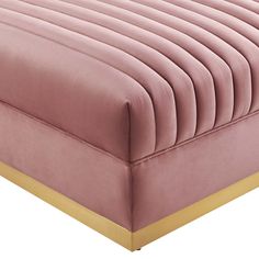 a pink bed with gold trim on it