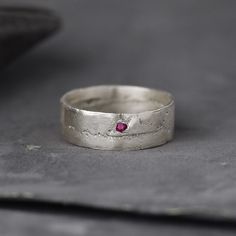 a silver ring with a pink stone in it